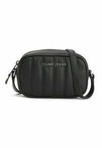 Black synthetic crossbody bag with quilted texture, zip closure, and adjustable strap. Features "TOMMY JEANS" logo in silver on the front.