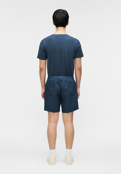 Σκούρο μπλε κοντομάνικο μπλουζάκι με στρογγυλή λαιμόκοψη, σετ με σκούρο μπλε σορτς που διαθέτει ελαστική μέση και δύο πίσω τσέπες.