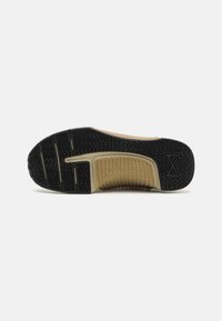 Black rubber shoe outsole with a textured pattern and a tan midsole. Features grooves and branding detail.