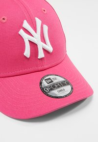 Casquette de baseball en coton rose avec un logo NY brodé en blanc, visière incurvée et arrière réglable. Comprend une étiquette circulaire New Era 9FORTY.