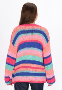 Chunky gestrickter Pullover mit horizontalen Streifen in Pink, Blau, Grün und Orange. Locker sitzend mit weiten Ärmeln und geripptem Halsausschnitt.