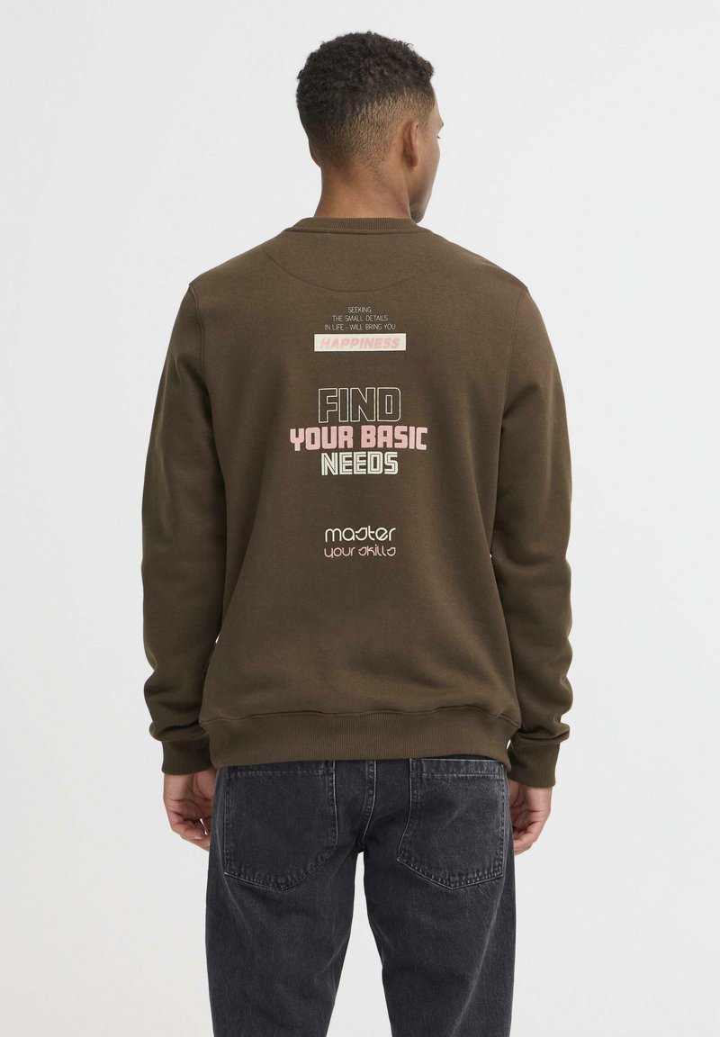 Sudadera marrón con cuello redondo, que presenta texto impreso en la parte posterior. La tela parece suave, con puños y dobladillo acanalados.