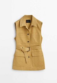Ärmlös khaki väst gjord av tyg med en slät textur, med två framfickor, ett bälte i midjan och en kragad halslinje.