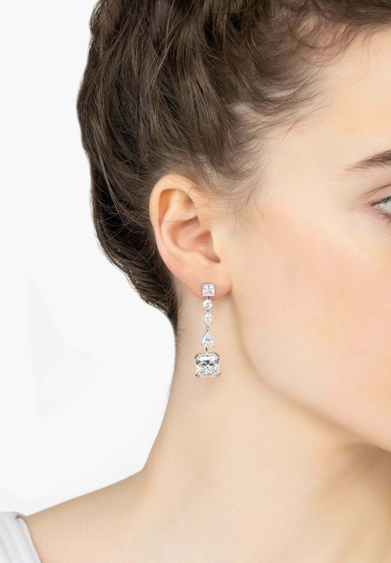Crystal drop earrings featuring a clear rectangular stone, smaller round and teardrop accents, set in silver-tone metal.