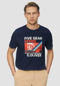 Navy blauwe katoenen t-shirt met een grafische print met rode, witte en blauwe accenten. De tekst luidt "FIVE GEAR DENIM" en "S.OLIVER."
