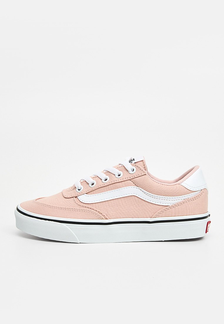 Zapatillas de lona rosa claro con acentos blancos, bordes negros y una superficie texturizada. Cuenta con cordones redondos y un diseño de caña baja.