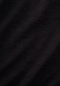 Tessuto nero con una sottile trama mottled. Il materiale appare morbido e traspirante, ideale per un abbigliamento informale o per essere indossato a strati.