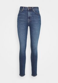 Vaqueros ajustados en denim azul medio. De tiro alto con una textura suave, con cinco bolsillos y cremallera con botón en la parte delantera.