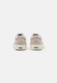 Light gray suede sneakers with white accents and a cream rubber sole. Logo on the back, cushioned collar, and lace-up design.