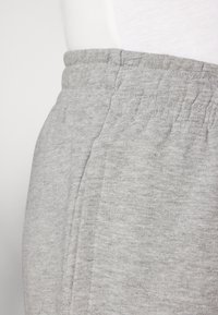 Grijze sweatpants met een elastische tailleband, zijnaad en een gestructureerde stof. Het materiaal lijkt zacht en geschikt voor casual draag.