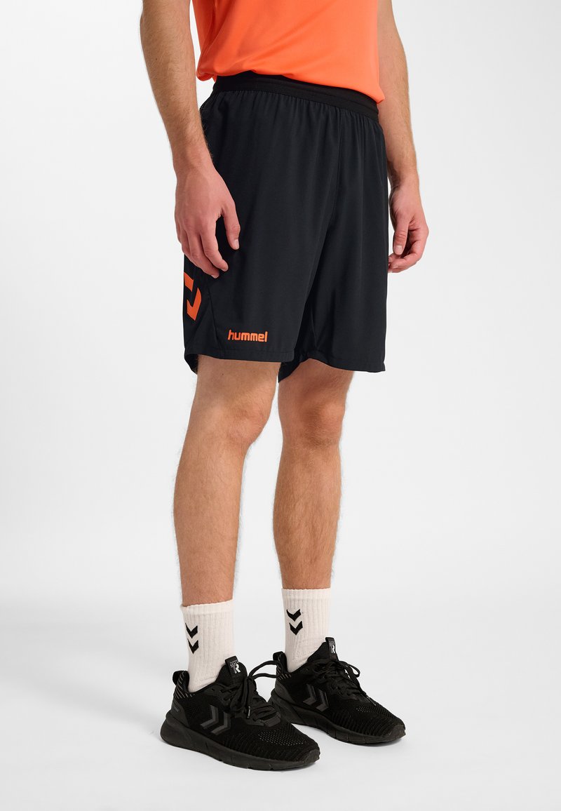 Svarta sportshorts med elastisk midjeresår, med en orange logotyp och detaljer. Materialet är lätt och något strukturerat.