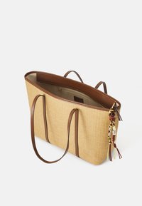 Borsa a tracolla in paglia intrecciata con dettagli e manici in pelle marrone. L'interno presenta una tasca con cerniera e un ornamento a frangia decorativo.