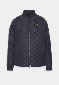 Granatowa pikowana kurtka z suwakiem z przodu, okrągłym kołnierzem, elastycznymi mankietami i żółtym logo na piersi. Posiada wyściełaną teksturę z geometrycznym wzorem.