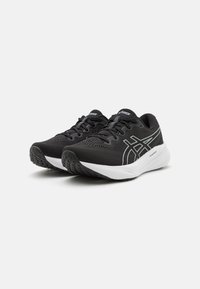 Baskets de sport noires avec un dessus en maille texturée, un amorti léger et une semelle intermédiaire blanche. Présente des accents réfléchissants discrets et une semelle en caoutchouc.