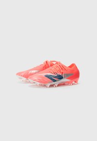 Scarpe da calcio rosa brillante con tomaia testurizzata, caratterizzate da una striscia diagonale blu e argentata, suola bianca e tacchetti sagomati per la trazione.