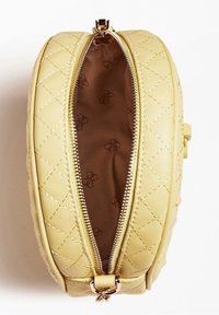 Okrągła żółta torba ze sztucznej skóry z pikowanym wzorem, złotym zamkiem błyskawicznym i brązową podszewką wewnętrzną z powtarzającym się motywem logo.