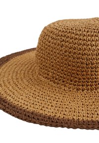 Sombrero de paja tejido con ala ancha, de color marrón claro natural y una banda marrón oscuro en la base. Superficie texturizada con forma redonda.