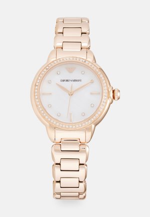 Reloj en oro rosa con correa de acero inoxidable, esfera redonda de nácar blanco, bisel adornado con cristales y diseño de esfera minimalista.