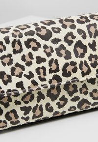 Kopertówka w leopardzie w beżowo-czarnym kolorze, z gładką, teksturowaną powierzchnią i wyraźnymi plamkami, o eleganckim prostokątnym kształcie.