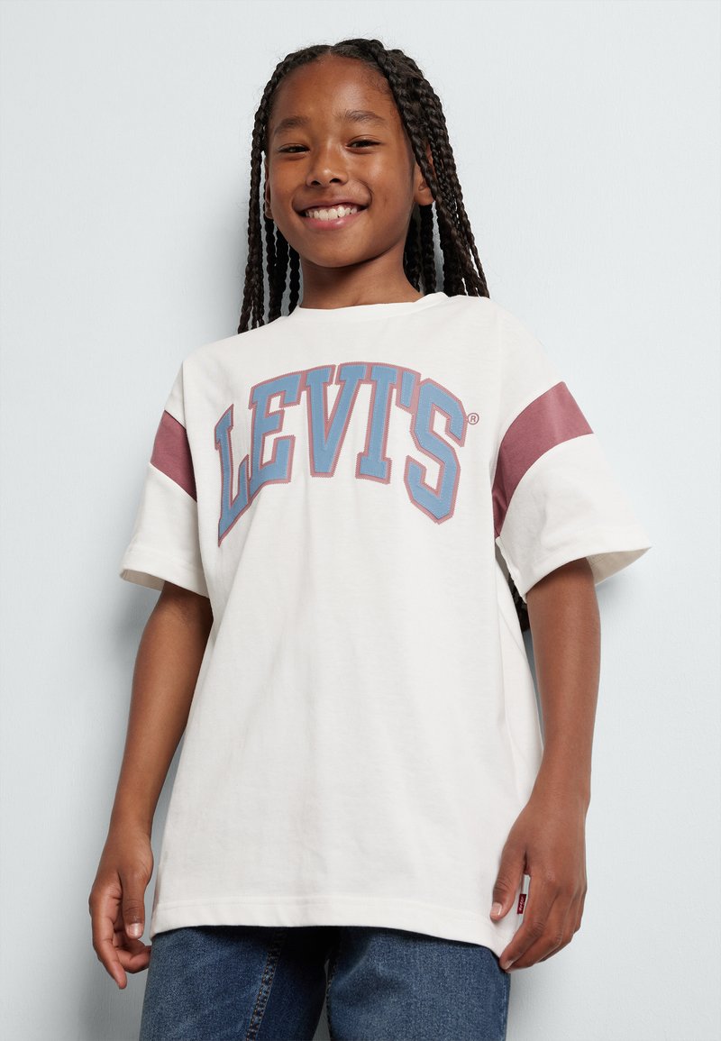 Camiseta blanca con acentos burdeos, con texto grande "LEVIT'S" en azul. Mangas cortas, corte relajado y material de algodón suave.