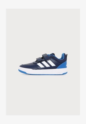 Chaussure de sport bleu marine et blanche avec deux bandes velcro, doublure intérieure bleue et semelle blanche avec des accents bleus, vue de profil.