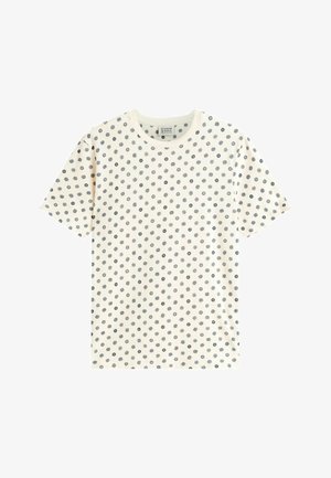 Camiseta blanca de manga corta con pequeños patrones de sol negro y puntos circulares que cubren uniformemente la tela.