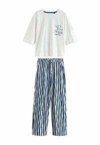 Camiseta blanca de manga corta con la frase "QUEDÉMONOS EN LA CAMA PARA SIEMPRE" impresa. Pantalones de pijama a rayas azules y blancas con cintura elástica y piernas anchas.
