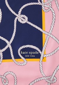 Roza tkanina s tamnoplavim kvadratom, isprepletenim bijelim uzorcima užeta i zlatnim logotipom koji glasi "kate spade NEW YORK."