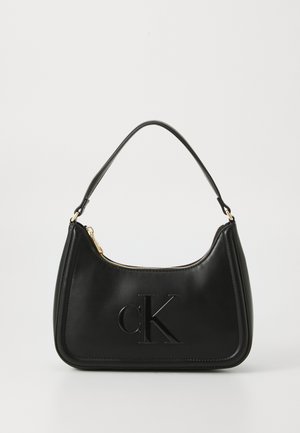 Bolsa de couro preta com uma forma arredondada, com um fecho dourado e um discreto logotipo "cK" em relevo. Textura suave e uma alça única.