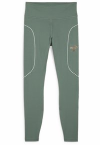 Vihreät legginsit, jotka on valmistettu joustavasta kankaasta. Niissä on kontrastiväriset valkoiset ompeleet, korkea vyötärö ja kultainen Puma-logo vasemmalla puolella.