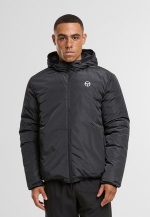 Zwarte geïsoleerde jas met een capuchon, voorzien van een frontale rits en zijzakken. Subtiel logo op de borst. Soepele textuur en puffy ontwerp.