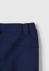 Navy blue pants with a smooth texture, featuring an elastic waistband and a stitched seam detail at the top.
