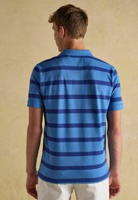 Herren Polo-Shirt in Blau mit gestreiftem Muster, das abwechselnd helle und dunkle blaue Streifen zeigt, mit kurzen Ärmeln und einem klassischen Kragen, aus weichem Stoff gefertigt.