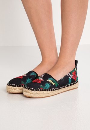 Black canvas espadrilles featuring a floral pattern with red flowers and green leaves, jute-style rope soles, and a smooth textile finish.