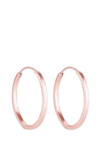 Boucles d'oreilles créoles en or rose avec un design lisse et arrondi, et une texture intérieure striée. Fixées par un fermoir à charnière pour un port facile.