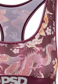 Close-up van een kastanjebruine sport-bh met een roze en oranje draak en bloem motief, met een racerback ontwerp en een brede elastische band.