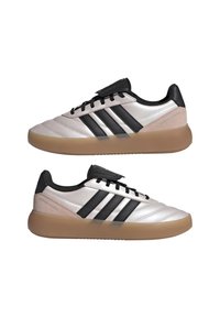 Zapatillas con un diseño elegante, que cuentan con una parte superior sintética plateada, rayas negras y suela de goma. Incluyen detalles texturizados en el talón.