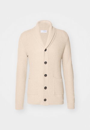 Beige gebreide cardigan met sjaalkraag, vijf donkere knopen, een gestructureerde stof en twee voorzakken. Lange mouwen met ribbels aan de manchetten.