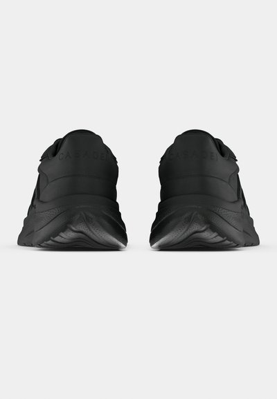 Μαύρα αθλητικά παπούτσια με λείο υφασμάτινο ε πάνω μέρος, κυρτή σόλα και επενδυμένο γιακά. Διαθέτουν ανάγλυφο λογότυπο στο πίσω μέρος και ανάγλυφο μοτίβο στο πέλμα.