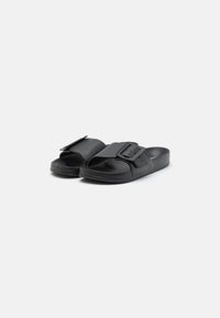 Schwarze Slidesandalen aus synthetischem Material. Sie verfügen über einen breiten Riemen mit einer rechteckigen Schnalle und ein strukturiertes Fußbett für zusätzlichen Komfort.