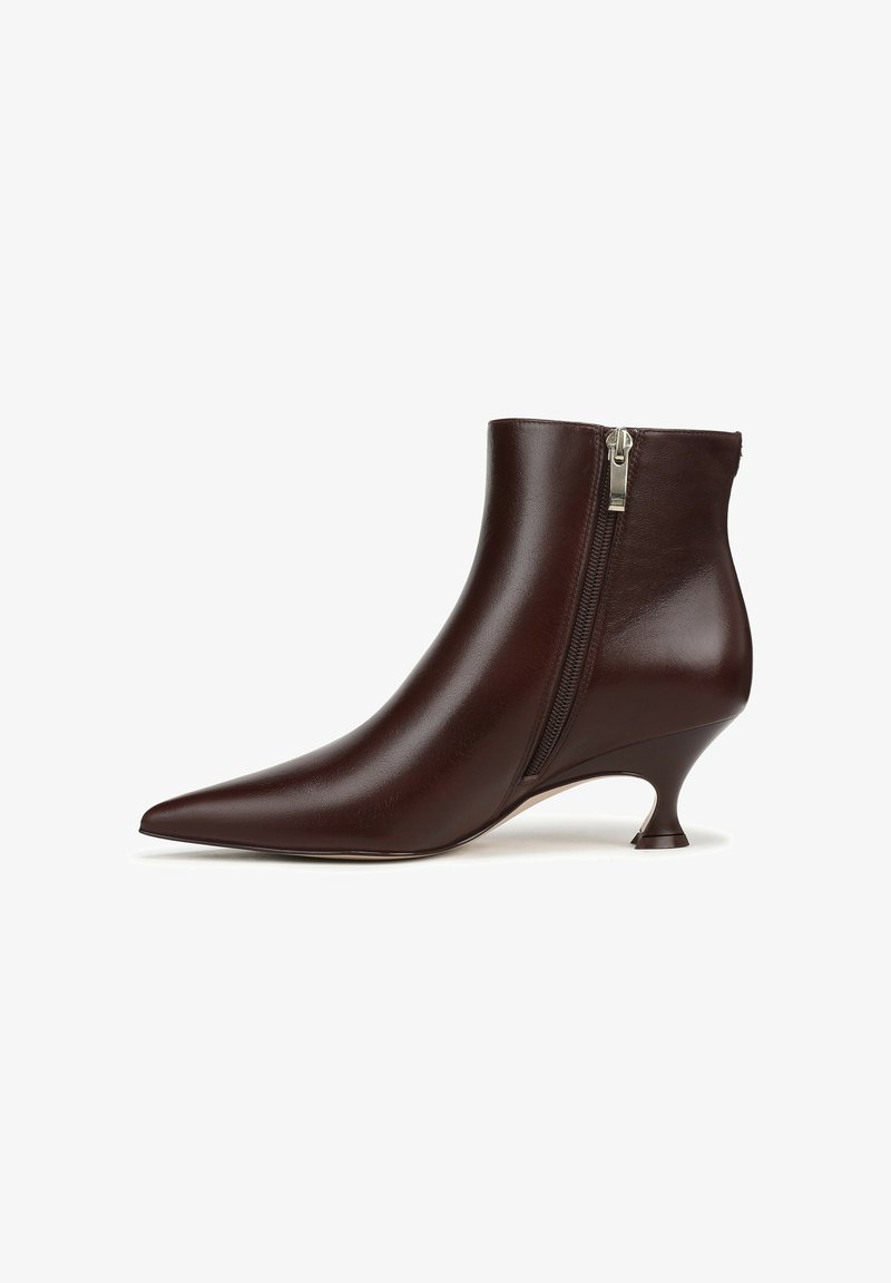 Bottine en cuir brun avec un bout pointu, fermeture éclair latérale et un petit talon incurvé. Texture lisse avec une finition brillante.