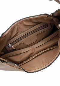 Innenraum einer braunen Lederhandtasche mit Reißverschlusstasche und offenen Fächern. Strukturiertes Finish und glatte Innenauskleidung. Reißverschlussverschluss.