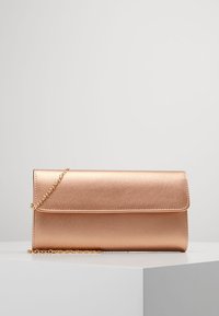 Metalická clutch v barvě růžového zlata s plochým obdélníkovým tvarem, hladkým povrchem a odnímatelným řetízkovým popruhem. Obsahuje jednoduchou překlapávací klapku.