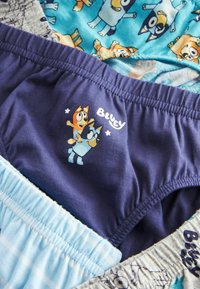 Drei Paare Kinderunterwäsche: eines in Blau mit Cartoon-Motiven, eines hellblau mit einem karierten Design und ein dunkelblaues Paar mit Cartoon-Figuren.