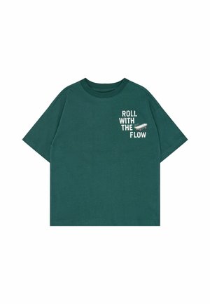 T-shirt vert foncé à manches courtes avec le texte « ROLL WITH THE FLOW » et un petit motif de skateboard sur la partie supérieure gauche de la poitrine.