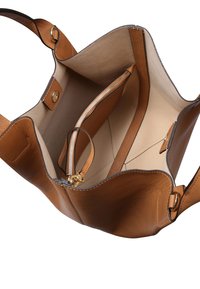 Brown leather handbag with a spacious interior, featuring a zippered pocket, smooth texture, and rounded edges. Gold-tone hardware accents.