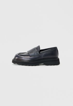 Navy farbener Leder Slipper mit abgerundetem Zehenbereich, strukturiertem Obermaterial und einer dicken schwarzen Gummisohle mit Zickzackmuster.