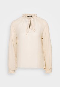 Krämfärgad långärmad blus med volangdetalj vid halsen och knytning. Har en mjuk textur och en avslappnad passform med elastiska ärmslut.