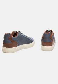 Sinised kõrgevarvased sneakersid pruunide nahkaaktsentidega, tekstureeritud pind, kummist talla ja lipsudega disain. Paar on näidatud külg- ja taganurgast.