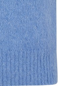 Nahaufnahme von weichem, fusseligem blauen Strickstoff mit sichtbaren Fasern und gerippter Textur am unteren Rand.